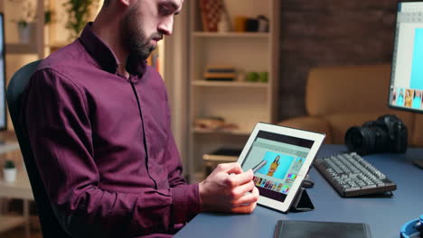 Side-view-photographer-doing-retouching-on-tablet-computer