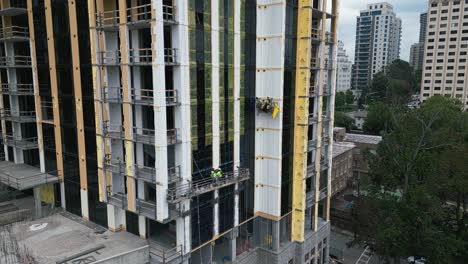 Vista-Aérea-Del-Trabajador-En-El-Ascensor-Para-Construir-Una-Nueva-Torre-Moderna-En-La-Metrópolis-Americana---Atlanta,-Georgia