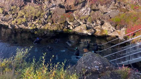 Turistas-Buceando-En-Aguas-Frías-De-La-Falla-Tectónica-De-Silfra,-Islandia