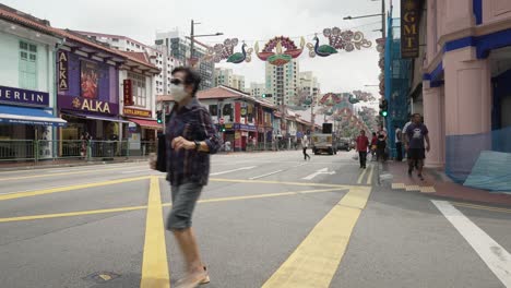 Corner-Of-Dunlop-Street-Leading-Onto-Serangoon-Road-In-Little-India,-Singapore-In-September-With-Traffic-Going-Past-And-Diwali-Decorations-Hanging-Between-Lampposts