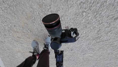 POV-Blick-Auf-Die-Kamera-Auf-Dem-Gimbal-Stabilisator-Im-Unterbaumodus-Beim-Filmen-Entlang-Des-Straßenbelags