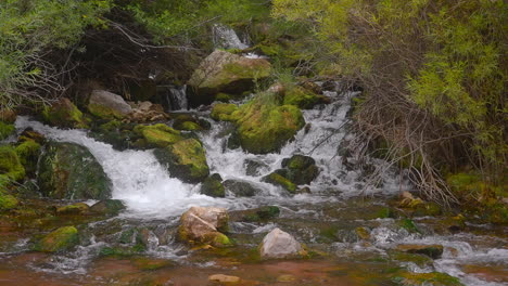 Agua-Que-Fluye-Hacia-Las-Rocas-Cubiertas-De-Musgo-En-Las-Cascadas