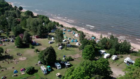 Drohnenansicht-Von-Menschen,-Die-In-Der-Nähe-Der-Ostseeküste-Mit-Zelten-Und-Wohnmobilen-Campen