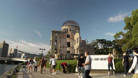 Tourists-visiting-Atomic-Bomb-Dome-in-Hiroshima,-Japan-on-sunny-afternoon
