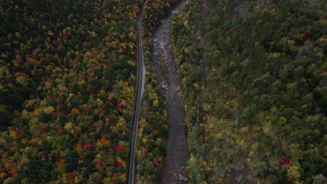 Aerial-reveal-of-national-scenic-byway,-Kancamagus-Highway-during-fall