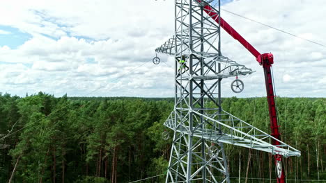 Drone-footage-shows-workers-on-a-high-voltage-line-working-with-cherry-picker