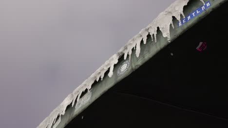 Winter-in-the-mountains,-frozen-roof,-water-melting-from-icicles,-Sniezka-mount,-slow-motion