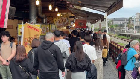 People-walk-along-the-shops-and-restaurants-in-Shifen-Old-Street-in-Pingxi-District,-Taipei,-Taiwan