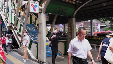 People-going-down-and-up-the-stairs-to-the-BTS-Phrom-Phong-Station-in-Sukhumvit,-Bangkok,-Thailand