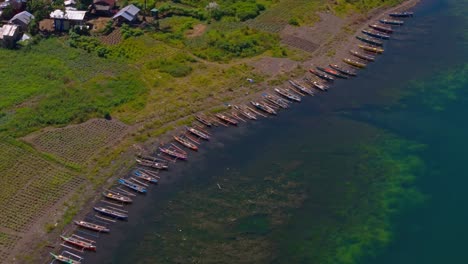 Drone-View-of-Fishing-Boats-Docked-on-Shore-of-Lake-Mainit,-Philippines