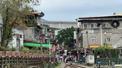 View-of-lanterns-set-off-into-the-sky-in-Shifen's-old-street-with-railroad-tracks-run-through-shops-and-restaurants-in-Pingxi-District,-Taipei,-Taiwan