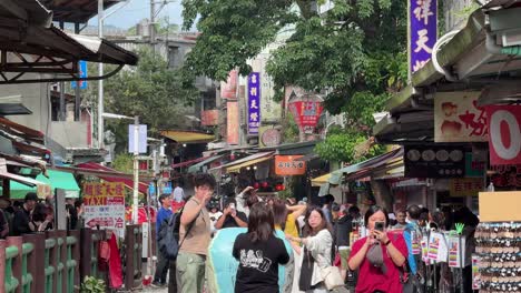 Touristen-Machen-Wünsche-Und-Zünden-Laternen-In-Den-Himmel-In-Shifens-Alter-Straße-Mit-Eisenbahnschienen,-Die-Durch-Geschäfte-Und-Restaurants-Im-Bezirk-Pingxi,-Taipeh,-Taiwan-Führen