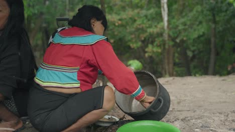 2-Frauen-Reinigen-Töpfe-Mit-Ihren-Händen-Im-Amazonas-Dschungel