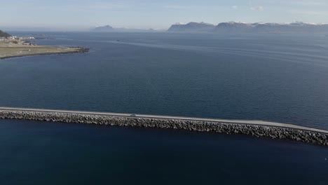 Aerial-tracking-shot-of-vehicle-driving-on-Runde-Bridge-during-sunny-day-in-Norway,-Europe