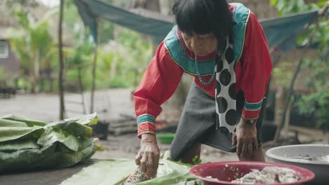 Mujer-Indígena-Rellenando-Un-Pescado-Con-Hierbas,-Selva-Amazónica,-Perú