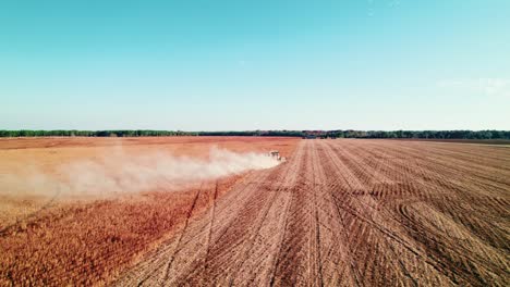 A-soybean-combine-leaves-a-trail-of-dust-behind-it-during-harvest
