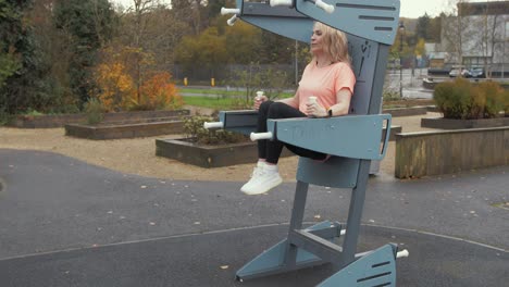 Woman-doing-knee-raises-working-out-in-park,-Wide-Shot