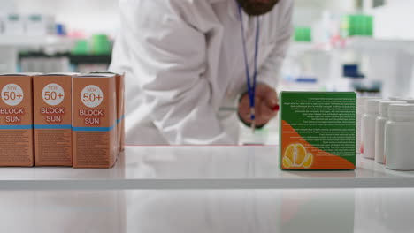 POV-of-pharmacist-putting-natural-vitamins-boxes-on-shelves