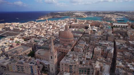 Aufsteigende-Umlaufbahn-Um-Die-Kuppel-Der-Basilika-Unserer-Lieben-Frau,-Während-Wolken-Die-Gebäude-Von-Valletta,-Malta,-Bedecken