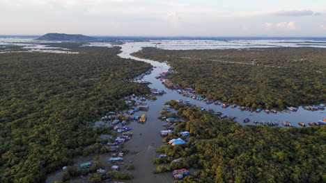 Local-Fisherman-Drives-Boat-Through-River-Village-in-Cambodia