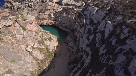 People-Sunbathing-and-Swimming-in-Canyon-Blue-Lagoon-on-Gozo-Island,-Wied-il-Ghasri,-Malta