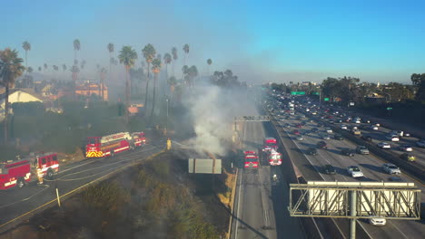 Bomberos-Y-Camiones-De-Bomberos-Trabajando-En-Una-Carretera-Muy-Transitada-En-Los-Ángeles,-EE.UU.---Vista-Aérea