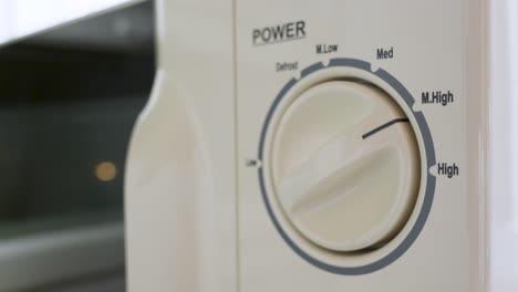 Man-adjusting-the-power-setting-on-a-microwave-oven