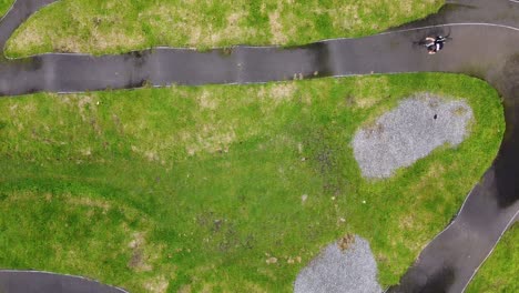 A-top-down-drone-shot-of-a-young-cyclist-on-a-pump-track