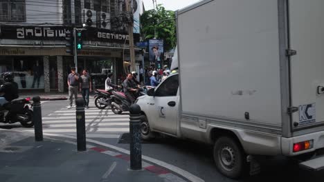 Un-Todoterreno-Blanco-Y-Un-Camión-De-Reparto-Interrumpen-A-Las-Personas-Que-Cruzan-El-Carril-Peatonal-Durante-El-Paseo.-La-Luz-Verde-Está-Encendida,-Sukhumvit-26,-Al-Otro-Lado,-Es-Beethoven-Tailing,-Bangkok,-Tailandia.