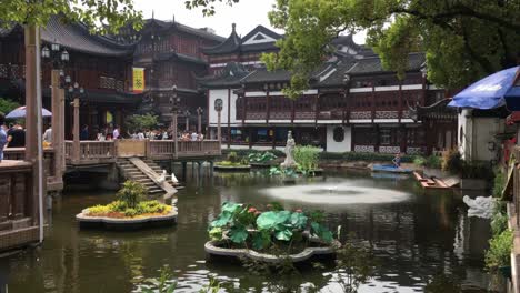 Water-pond-and-fountain-in-Yuyuan-Garden-in-Shanghai,-China,-with-a-lot-of-tourists