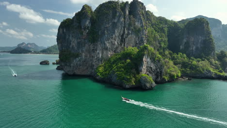 Traditional-Thai-Longtail-boat-driving-along-the-coast-of-Railay-to-Ao-Nang-Krabi,-Thailand