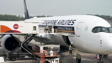 Arbeiter-Sah,-Wie-Er-Am-Flughafen-Changi,-Singapur,-Einen-Trolley-Wagen-Eines-Flugzeugs-Von-Einem-Flughafen-Catering-LKW-Schob,-Der-Die-Singapore-Airlines-A350-900-Bediente