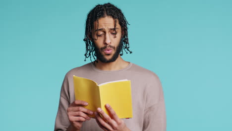 Man-reading-newly-released-hardcover-book-from-publisher,-studio-background