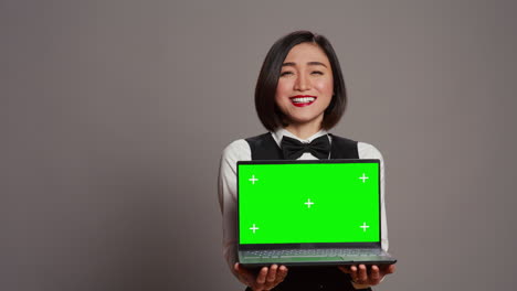 Receptionist-showing-greenscreen-display-on-personal-laptop,