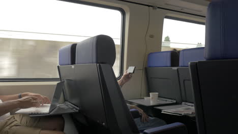 Hombres-Usando-Celular-Y-Laptop-En-Tren-De-Cercanías