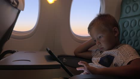 Bored-kid-with-pad-in-plane