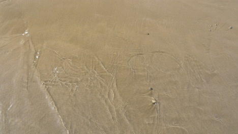 Sea-wave-washing-London-written-on-the-sand