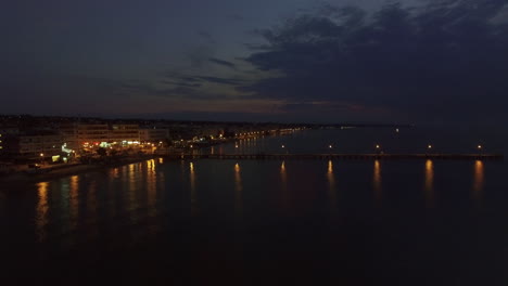 Aerial-view-of-resort-and-sea-with-pier-at-night