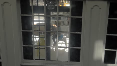 Family-having-breakfast-view-through-house-window