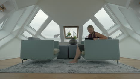 Woman-in-Cube-House-spending-free-time-with-tablet-computer