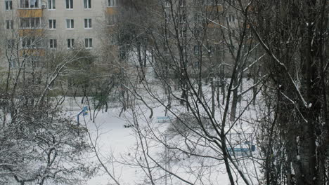 Winter-scene-of-residential-area-and-woman-walking-with-baby-stroller-Russia