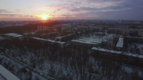 Flying-over-winter-city-and-moving-cargo-train-St-Petersburg-scene-at-sunrise