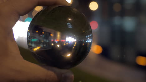 Looking-at-night-city-through-glass-ball