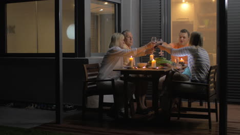 Close-up-of-family-clinking-glasses-and-eating-dinner