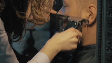 Close-up-view-of-woman-hands-cares-of-beard-Barber-combing-and-trimming-beard