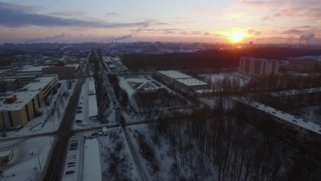 Aerial-view-of-cargo-train-crossing-winter-city-at-sunrise-St-Petersburg