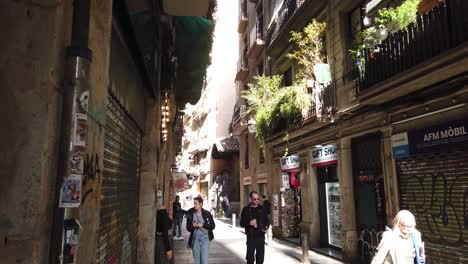 Los-Turistas-Caucásicos-Caminan-Por-Las-Estrechas-Calles-Góticas-Del-Raval-En-Barcelona,-España