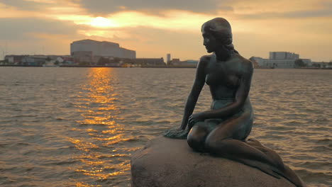 Mermaid-statue-on-the-stone-in-sea-at-sunset