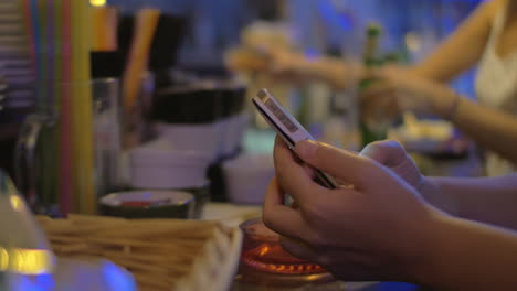 Woman-texting-on-mobile-in-the-bar
