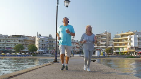 Pareja-Mayor-Corriendo-Con-Música-En-El-Muelle